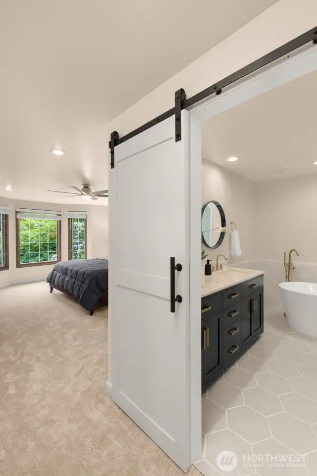 Stylish barn door separates primary bedroom from the ensuite bathroom.