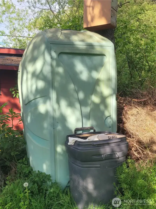 Extra large antique port-a-potty. Painted to match stand shed trim.