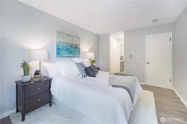 The Primary bedroom as seen from the slider doors looking into the bathroom.  The hallway is flanked by two large closets, one on either side