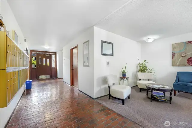 Lobby with mailboxes and sitting area to socialize.  The elevator is straight ahead on the left and the door at the end of the hallway takes you to the swimming pool and cabana