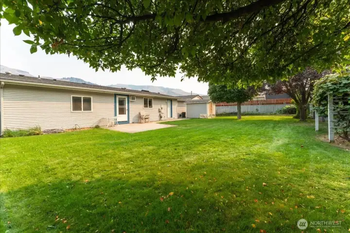 Pristine, manicured lawn framed by grapevines in the distance