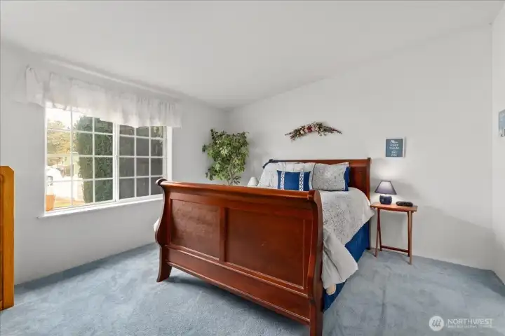 Bright, roomy primary bedroom with ample natural light