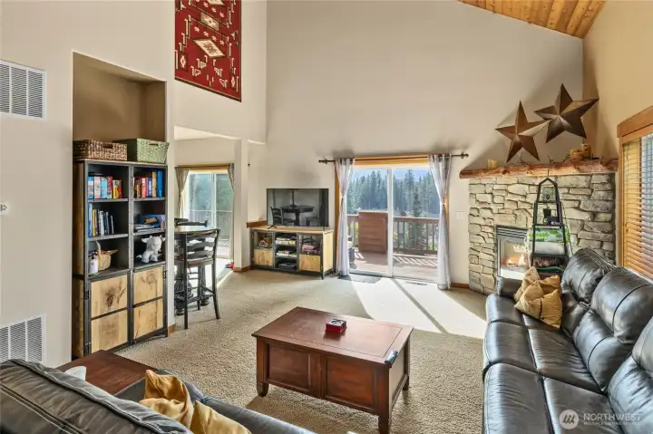 A stone fireplace with a handcrafted log mantle grounds the space in warmth and character.