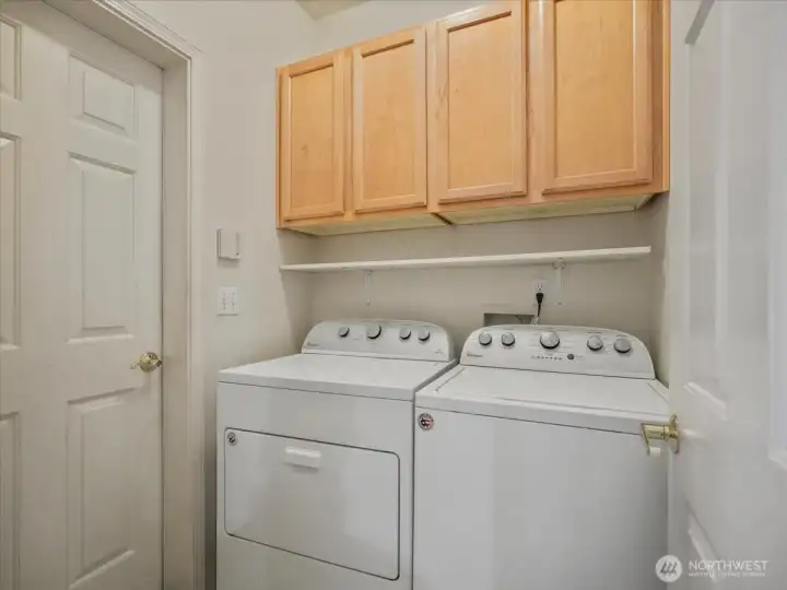 Washer and dryer stay with the home, complemented by built-in cabinets for organized storage.