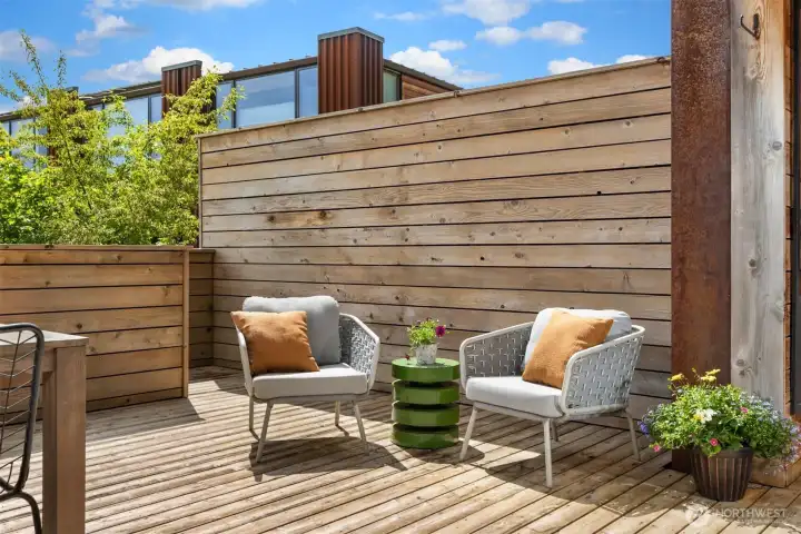 The stairs at the far side of the deck lead down to “The Grove,” a gorgeous common space with mature native plantings, trails, and a sweet community space with chairs and a fire table for gathering with neighbors.