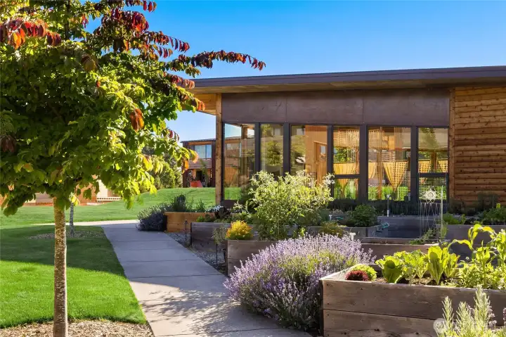Pea-patch gardens, brimming with beautiful and tasty treats and tended by residents, surround the beautiful community center.