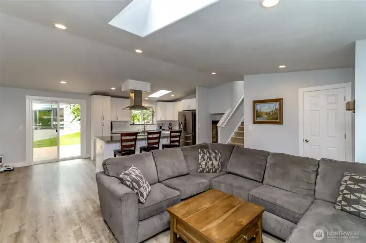 Living room off of the kitchen with dining room to the left of the kitchen island. The door is the coat closet.