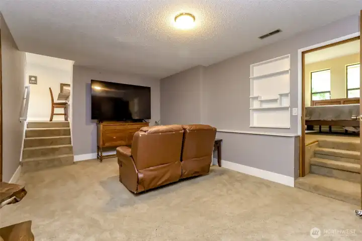 The family room is on the lower level from the living room and kitchen. To the right is the steps leading to this flex or bonus room with door access to the backyard.