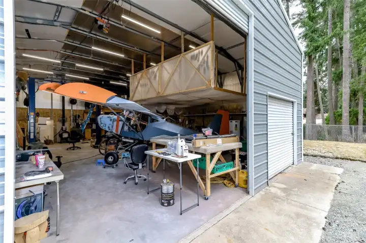 Roll up RV door leading to custom shop with tons of extras. Insulated, heat, AC, loft storage, temporary paint booth, fold up work table, TV with cable. Not much left to do here but bring your projects!