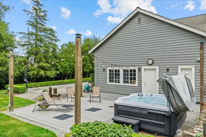 Warm Edison lighting and a peaceful water feature create inviting outdoor ambiance