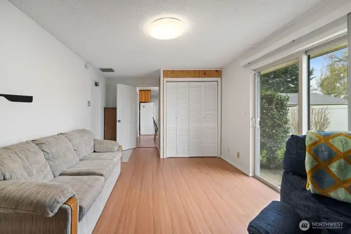 Every entertainment room need a door to the garage and sliders to the patio and flourishing plants, flowers and endless bed of grass.