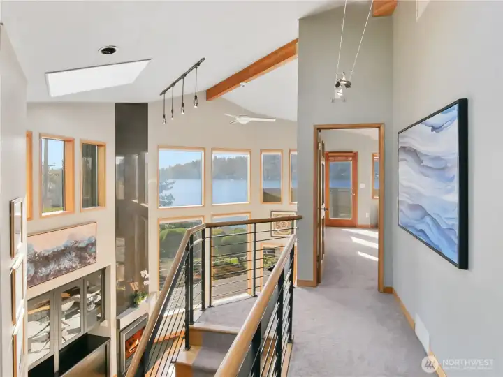 Open-concept upper landing with architectural railings overlooking the main living area below