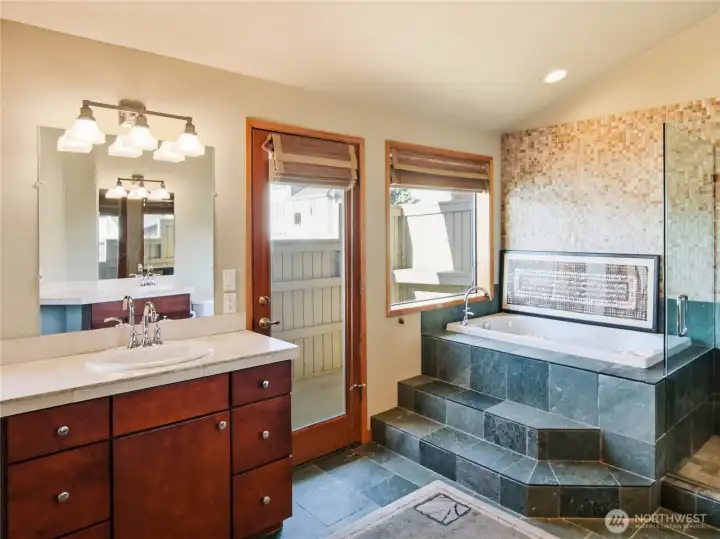 Elegant primary bath with custom vanity, rich wood cabinetry, and spa-inspired finishes