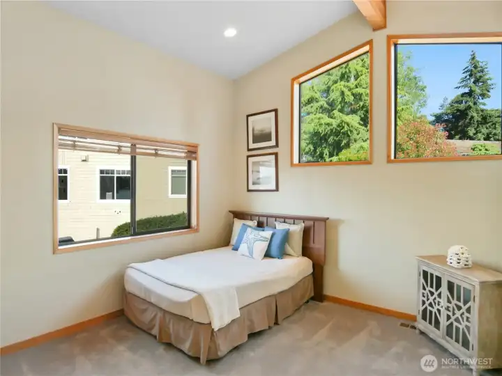 Comfortable bedroom with warm neutral tones, natural light, and direct access to additional living space
