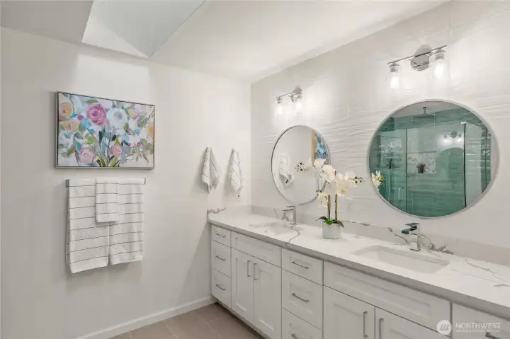 Primary bath suite with double vanity, fully tiled backsplash, quartz counters, custom mirrors and skylights.