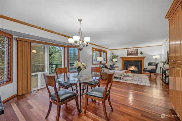 From Kitchen, view eat in space and family room with wood burning stove and ingress/egress to large low maintenance deck space.