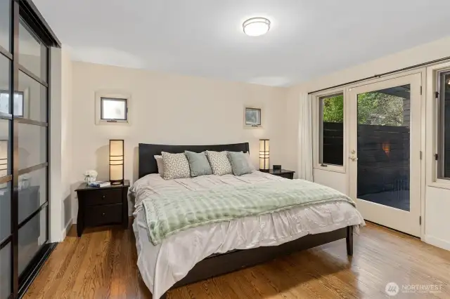 Primary bedroom features spacious wardrobe organizer, hardwood floors & private outdoor access.