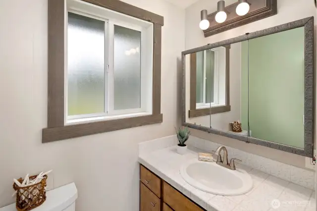 Bathroom with updated shower surround and vanity sink.