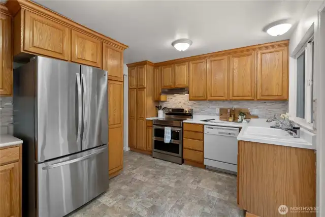 Your large kitchen has lots of room to move around and windows and a slider that over look the deck and greenbelt,
