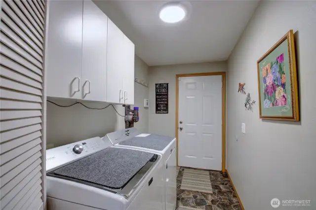 Hallway laundry room with door leading out to deck.