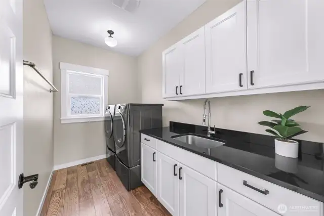 Large Laundry room with utility sink, tons of storage cabinets and washer/dryer stays with home!