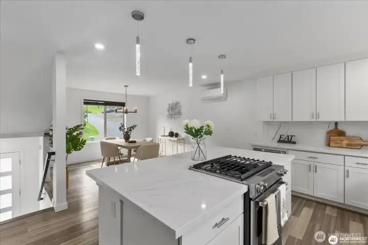 Quartz island and countertops provide ample space and storage, ideal for the discerning chef.