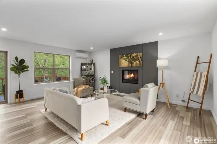 Windows flood the living area with light, showcasing the surrounding trees and forest while providing privacy