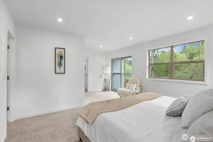 With its view of the trees, the primary bedroom is a tranquil, rejuvenating space.