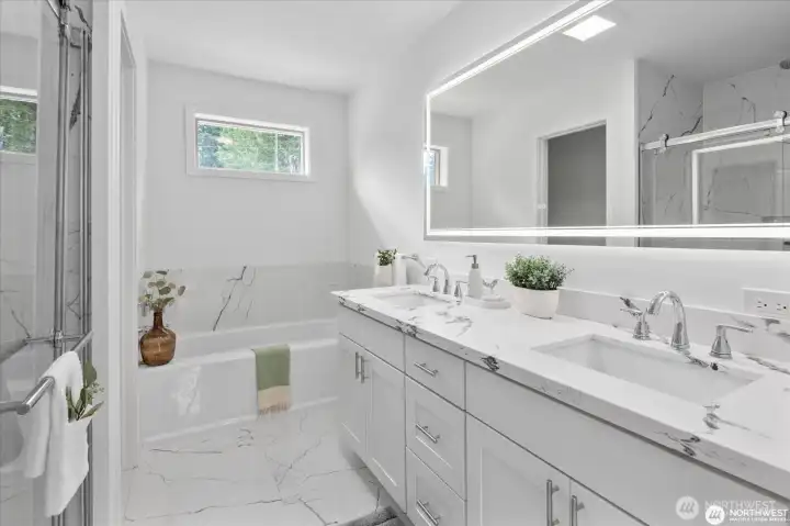 Spa like bathroom in the primary bedroom, with custom tile, quartz counters and LED mirror.
