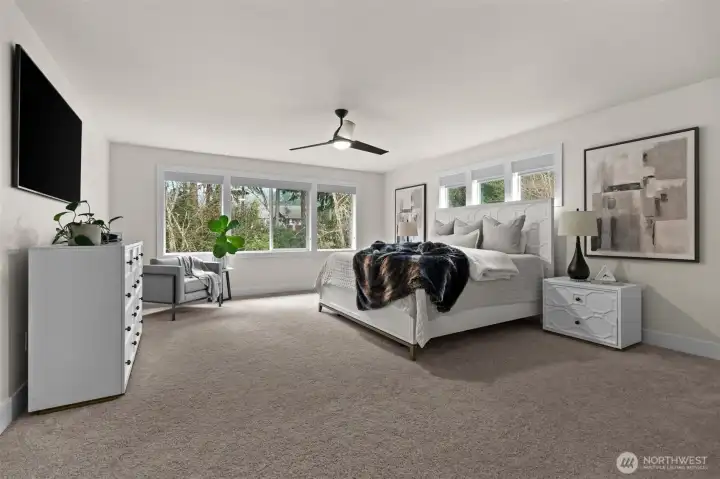 Unwind in this ultra-spacious primary room on the second floor, with wall-to-wall carpeting and flooding with light.