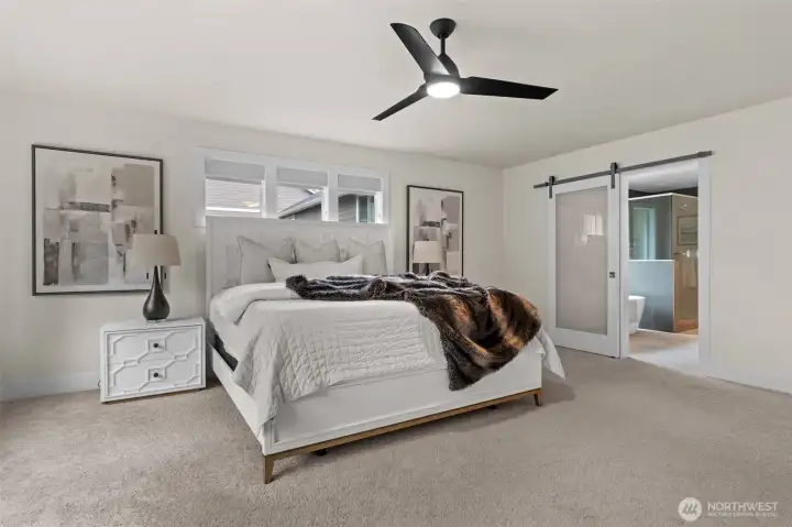 With it's own attached bathroom and trendy sliding barn door, this primary bedroom is designed for luxury.