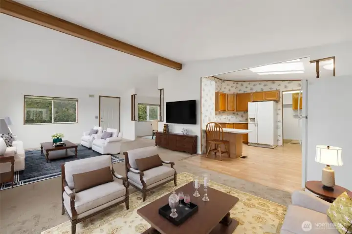 Bright, open living room with vaulted ceilings and large windows creating a welcoming gathering space. Photo virtually staged.