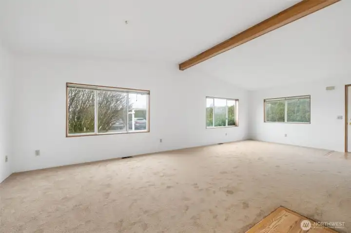 Large living room with expansive windows that bring in natural light and neighborhood views.