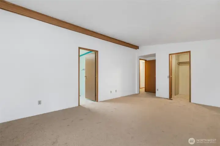 Spacious primary bedroom with convenient access to the ensuite bath, walk-in closet, and hallway.