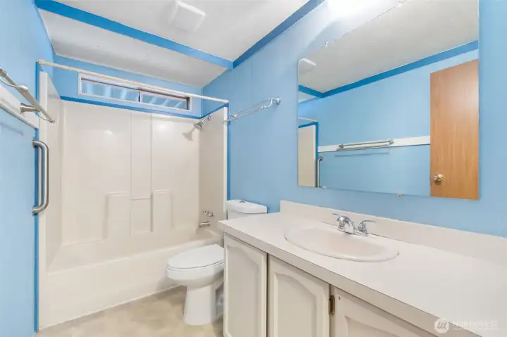 Full guest bathroom featuring tub/shower combo and generous vanity space.