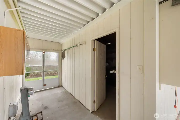 Versatile shop/storage space with workbench, shelving, and easy access to the backyard.