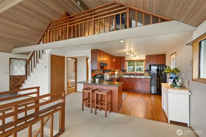 Updated kitchen with leathered slab granite and oak flooring. Main floor bedroom to left of kitchen as well as full bath.