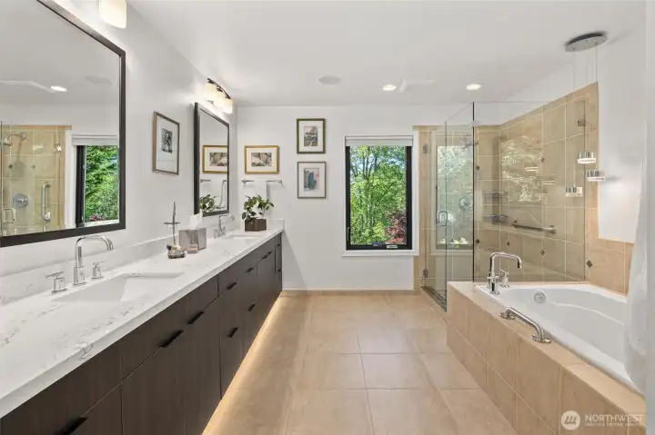 Primary bathroom has new cabinets, countertop, lighting and new glass for shower.