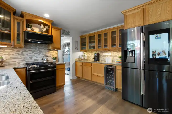 Designed with both everyday living and entertaining in mind, the kitchen offers abundant prep space, extended countertops, under-cabinet lighting, a dual-fuel range, wine refrigerator, and exceptional storage—making it as functional as it is inviting.