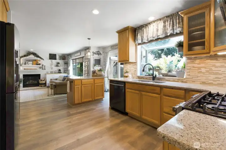 The heart of the home continues—this open-concept kitchen keeps everyone connected, whether you're preparing meals, entertaining guests, or simply enjoying everyday life around the fireplace and backyard retreat beyond.