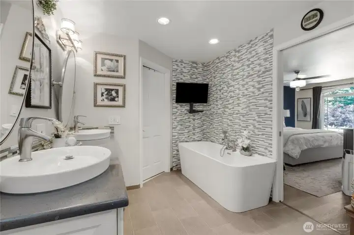 Unwind at the end of the day in the freestanding soaking tub, beautifully positioned against a striking designer tile feature wall that elevates the entire space.