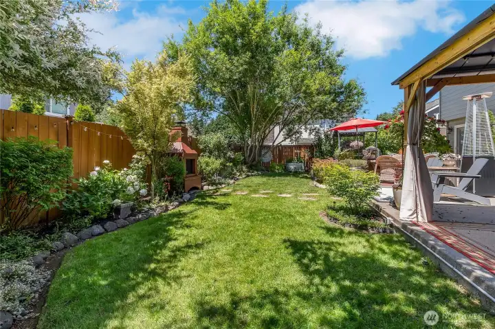 Mature trees, lush lawn space, and beautifully established landscaping create a backyard setting that feels private, peaceful, and inviting throughout the seasons.