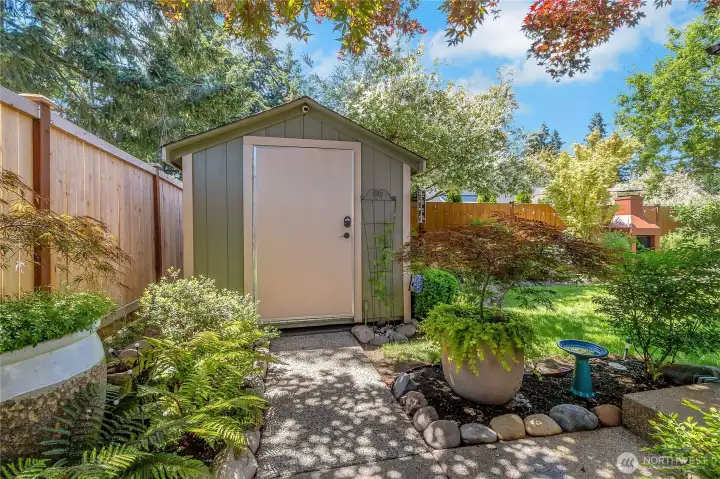 Even the utility spaces have been thoughtfully integrated into the landscape, with a storage shed (complete with lighting and electricity) tucked among mature plantings that add both function and charm.