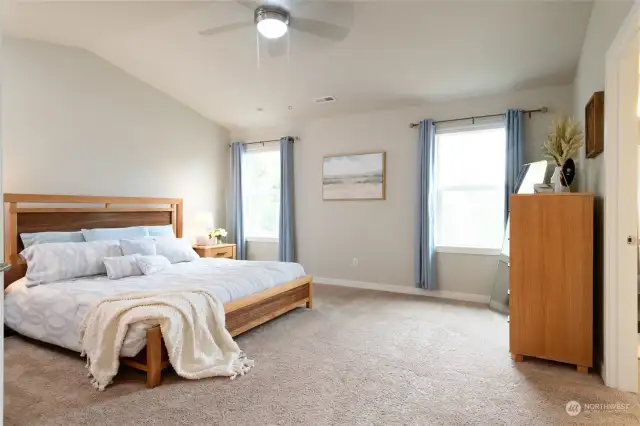 Upper floor Primary Bedroom with En Suite and walk-in closet. Vaulted ceilings and large windows bring in an abundance of natural light and create a sense of grandeur, spaciousness and elegance. Plenty of space for even the largest of bedroom sets.