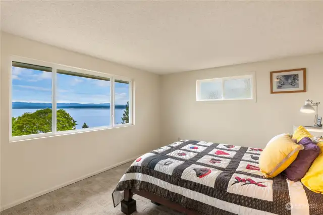 The main level primary bedroom offers stunning sound and mountain views overlooking Port Susan, creating a serene and picturesque retreat.