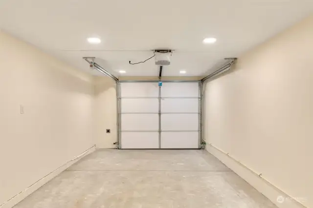 Spacious garage with EV charging outlet.