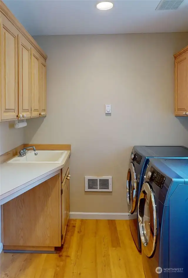 Laundry room just off the kitchen has a utility sink, cabinetry and direct access to your garage.