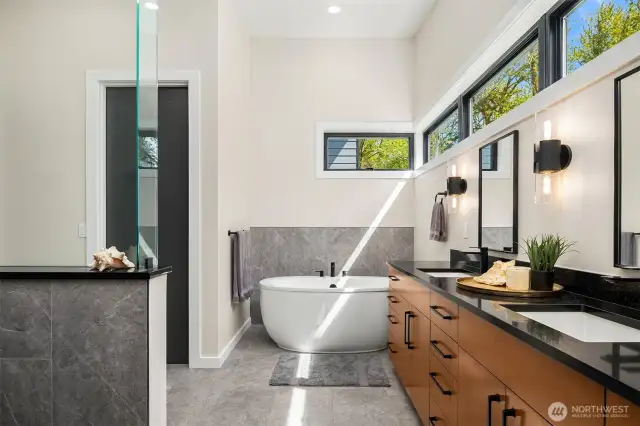 Luxurious primary bathroom with large double vanity, stand-alone tub, separate toilet and huge walk-in shower.
