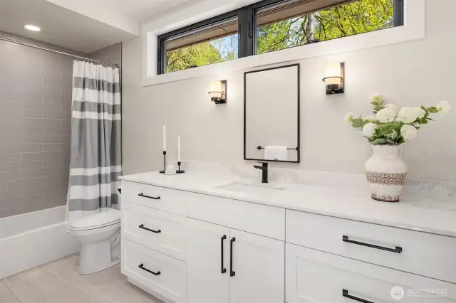 2nd Bedroom ensuite with tub, tile floors and quartz counter top.