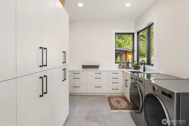 Huge laundry room loaded with storage, sink and plenty of countertop for folding or projects. Quartz counter top.